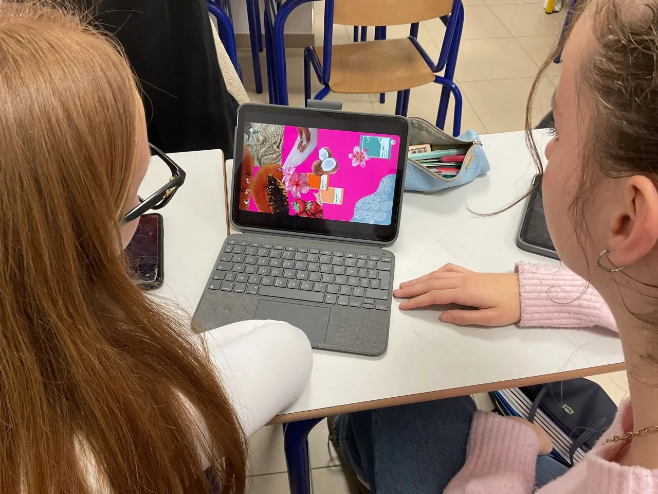 Students presenting a project visual on a tablet